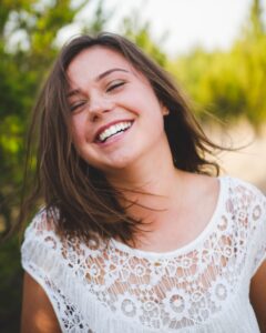 femme souriante portant un haut blanc