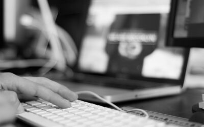 Clavier et écran d'ordinateur avec des mains sur les touches