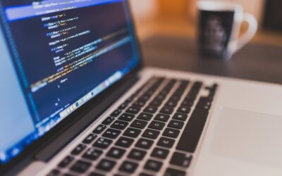 Ordinateur portable avec code sur l'écran et tasse de café